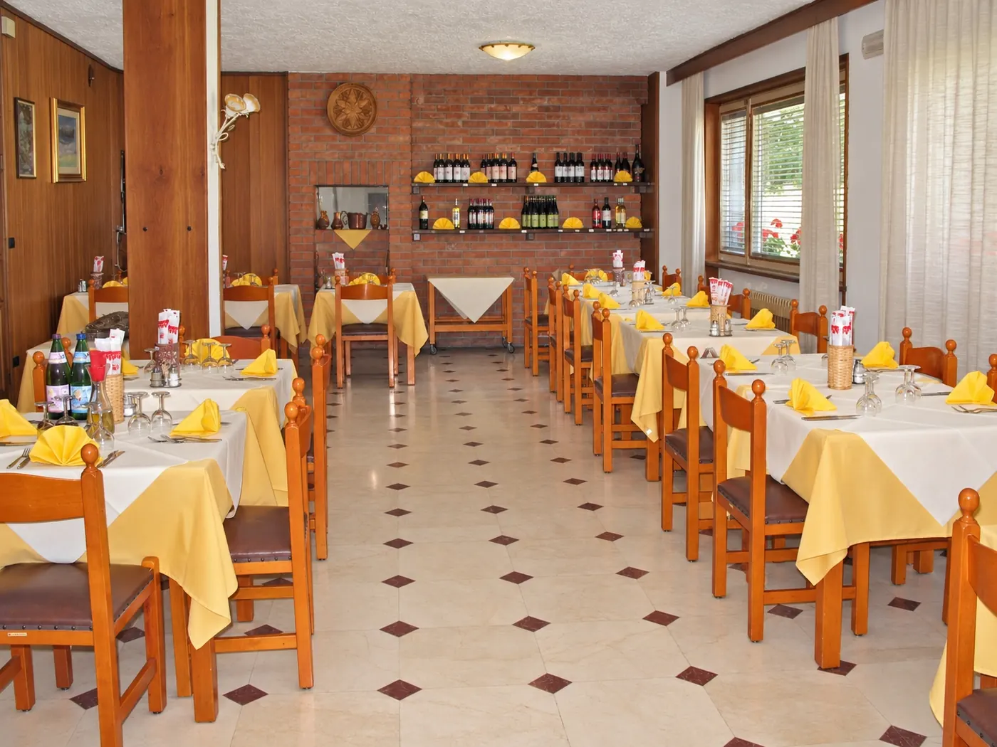 La sala del ristorante con le tovaglie gialle e le sedie arancio