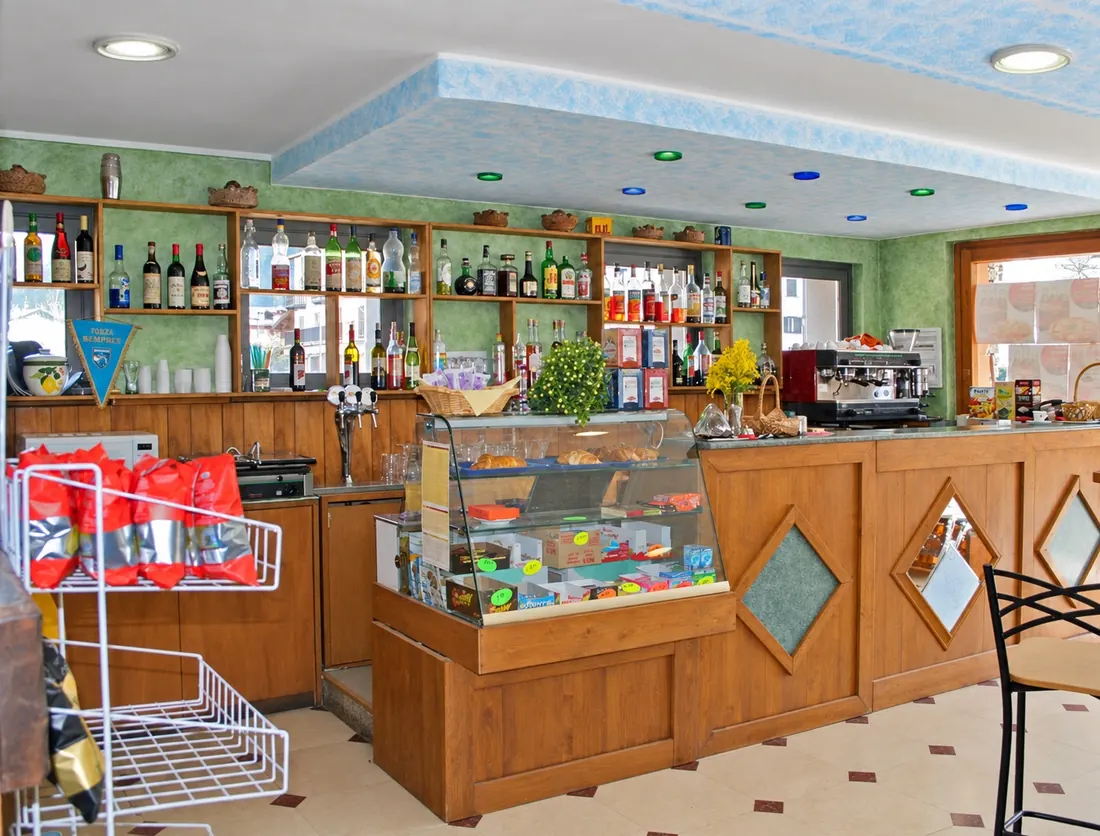 Il bar dell'albergo col bancone in legno e la vetrina